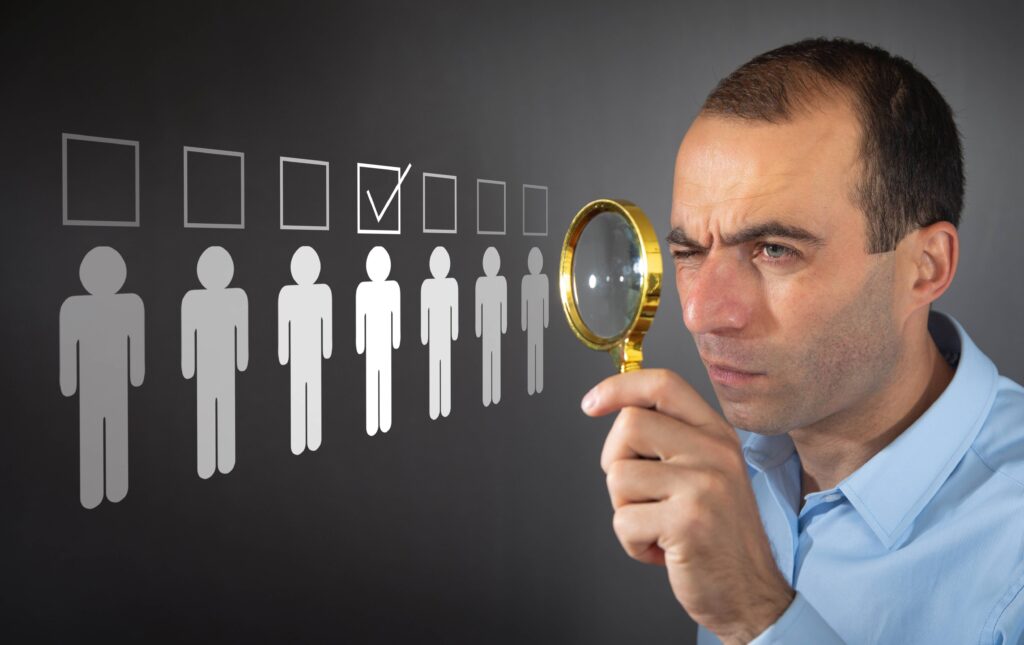 איש מסתכל בזכוכית מגדלת על שורה של אייקונים של איש